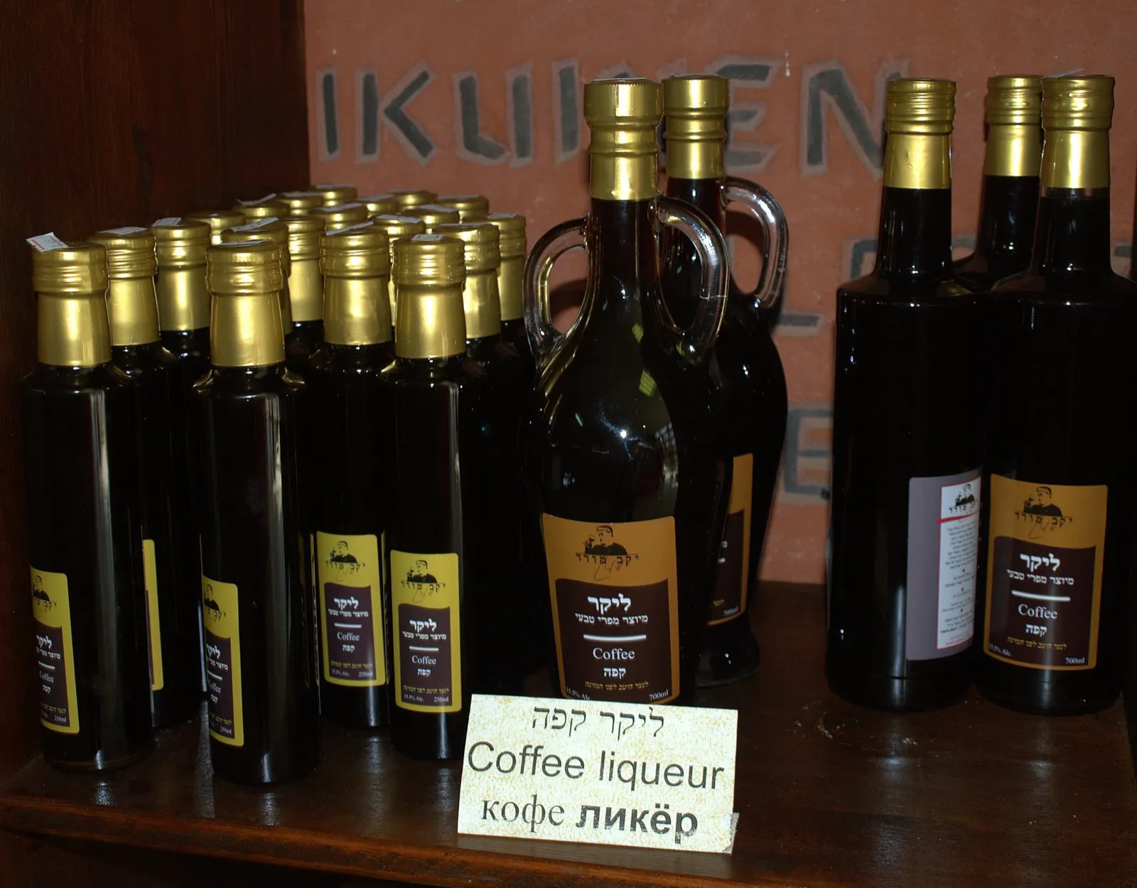 A bottle of coffee liqueur beside a small glass of dark liqueur