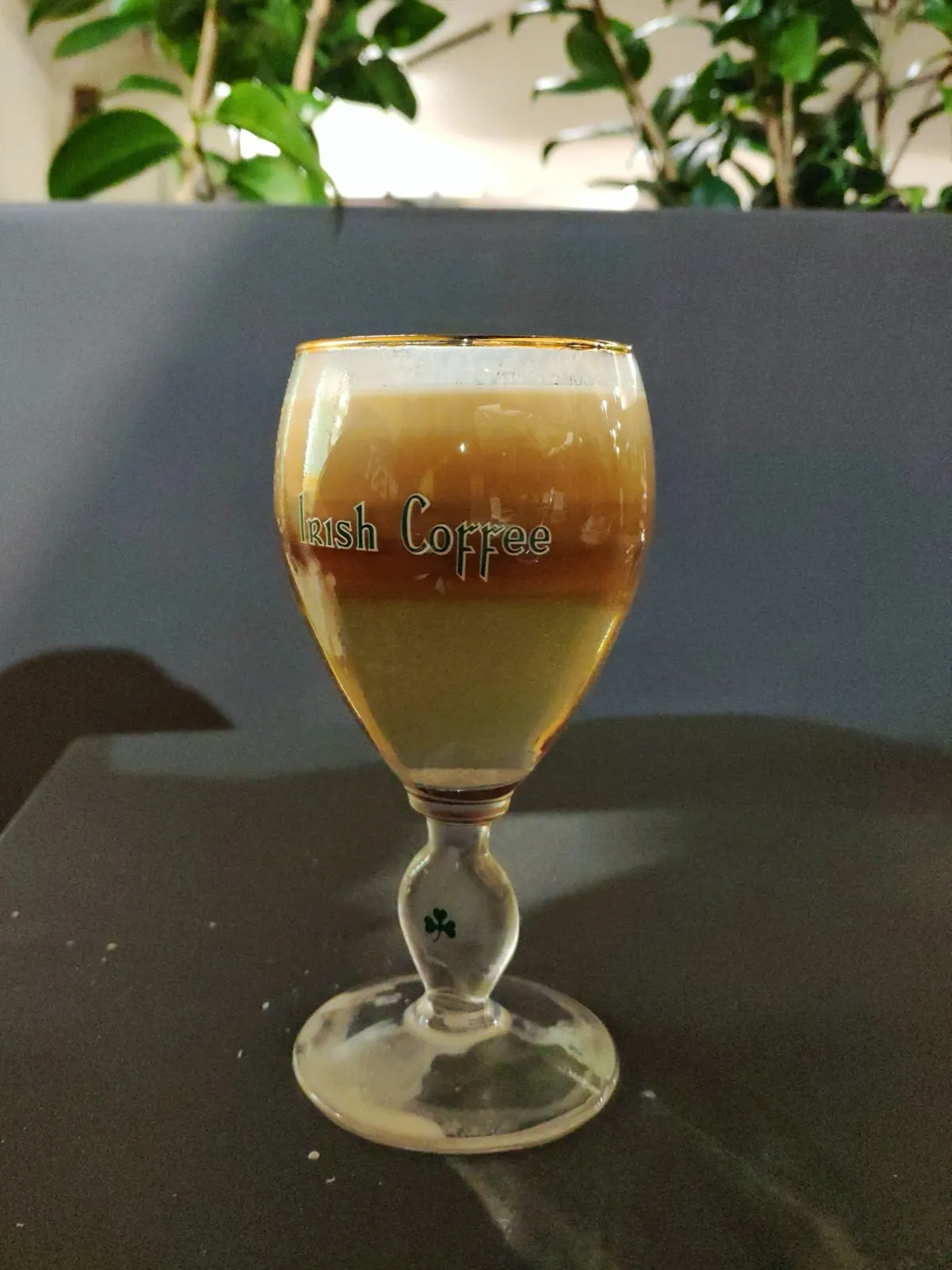 一杯分层的 Irish Coffee 风格咖啡威士忌饮品，上层有奶油泡沫