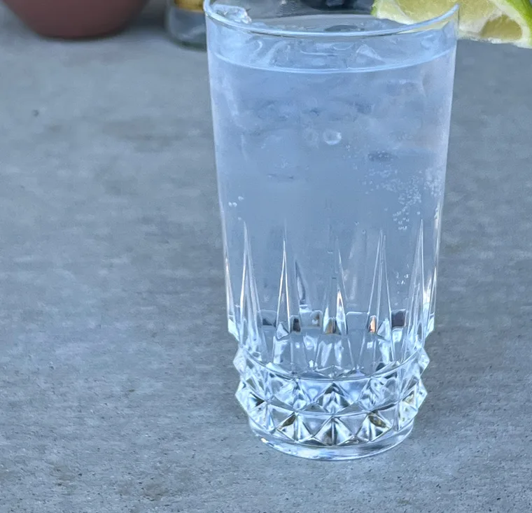 一杯加冰和青柠片的 Gin Tonic 放在桌面上