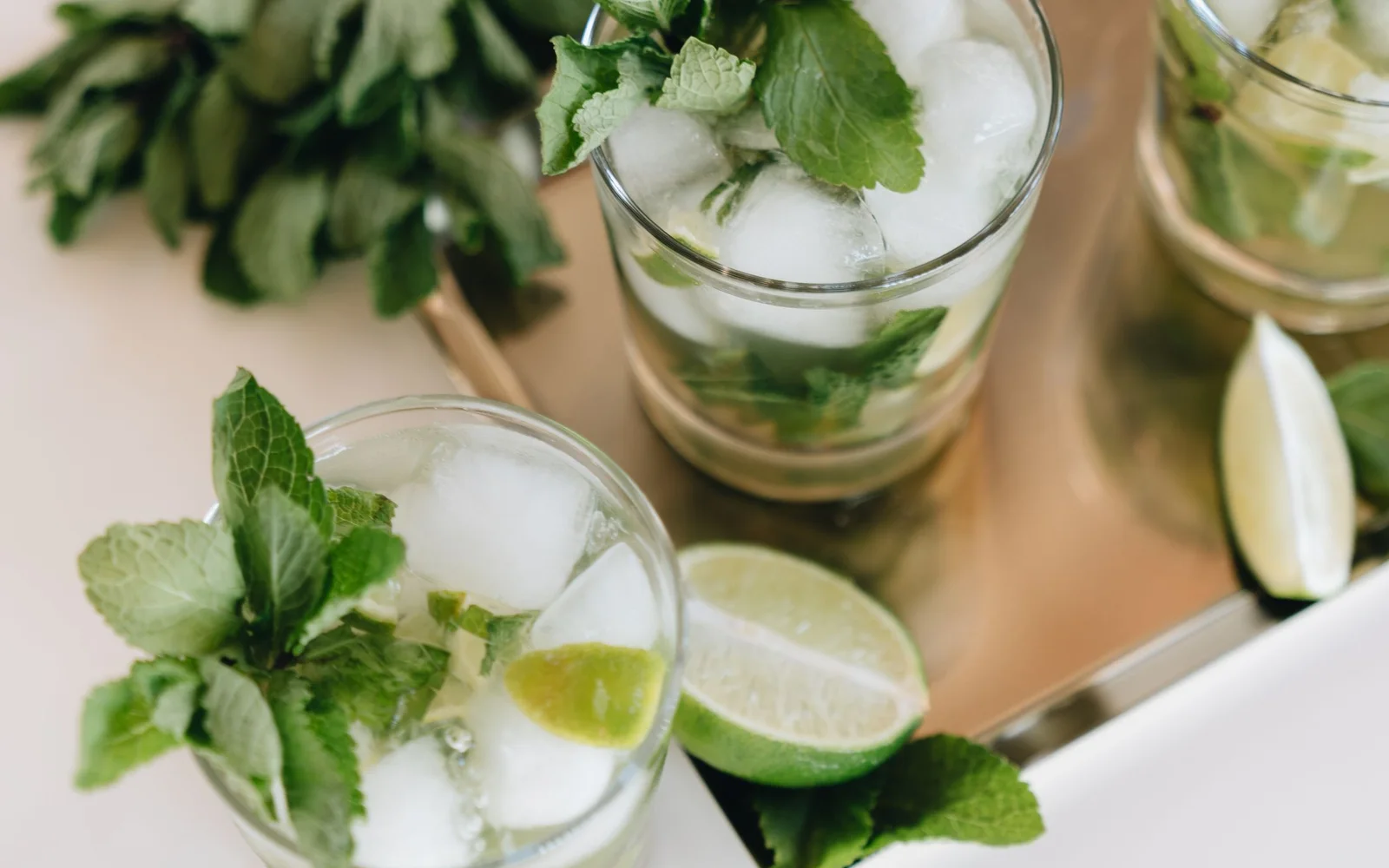 木板上放着薄荷、青柠和冰块的 Mojito 饮品