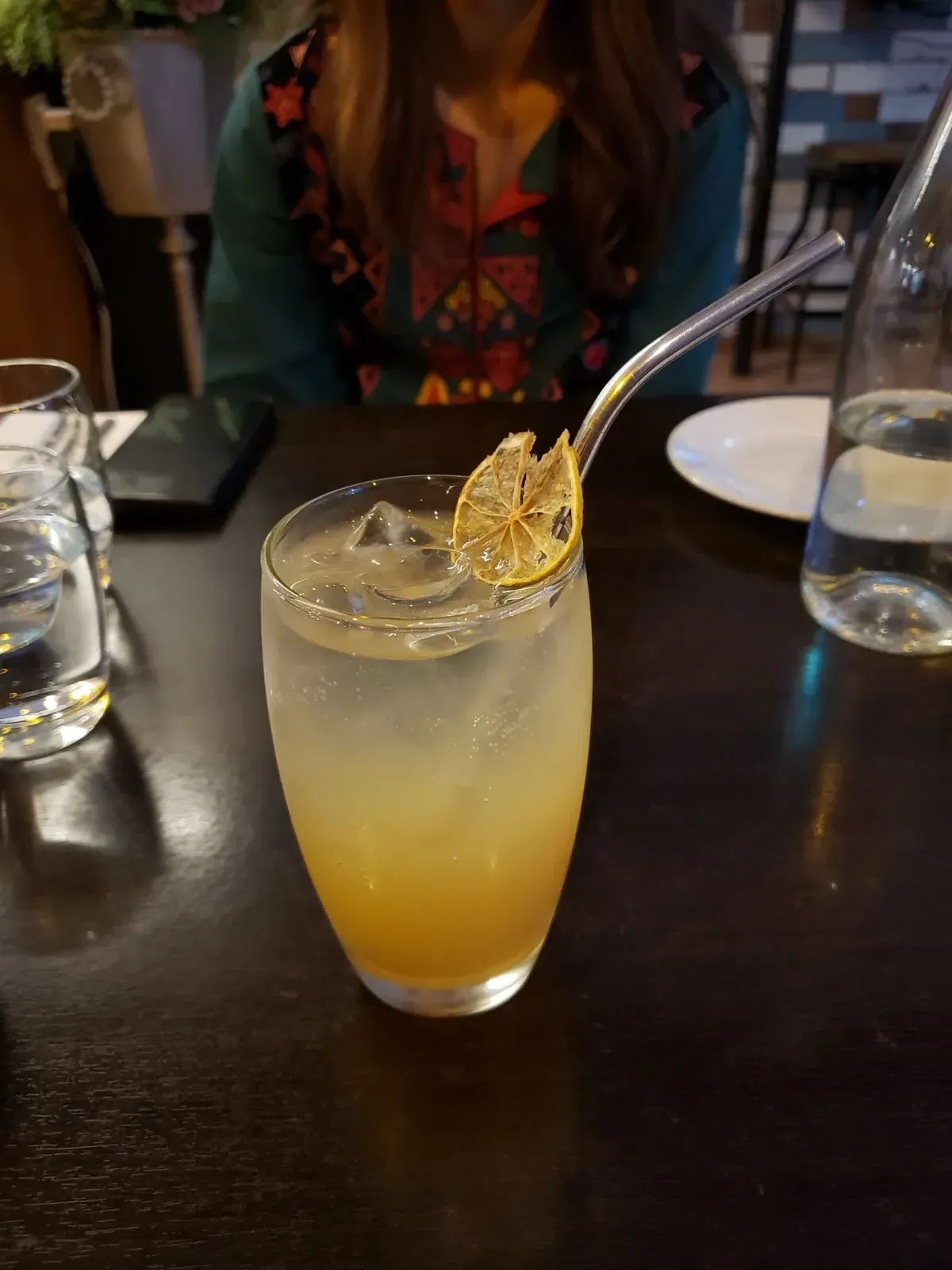 一杯浅色无酒精气泡饮，杯中有冰块和柠檬装饰