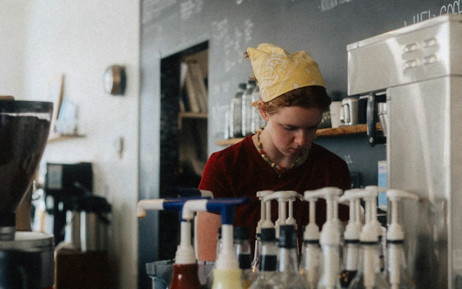 A cafe drink-making station with syrups and coffee equipment